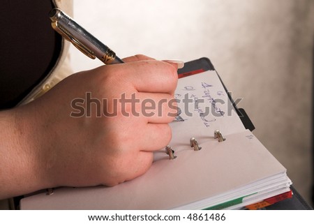 woman\'s hand with pen and notebook isolated