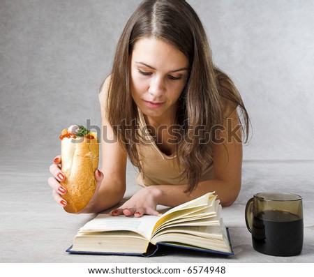 student with big book and hot dog