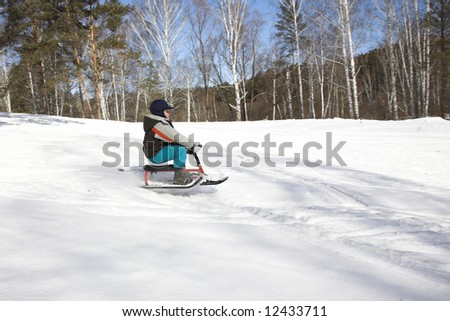 Little child on sledge on snowy mountain