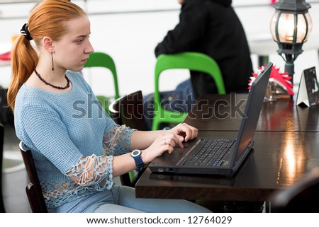 young girl working with computer in the cafe