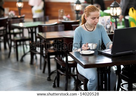 young girl working with computer in the cafe
