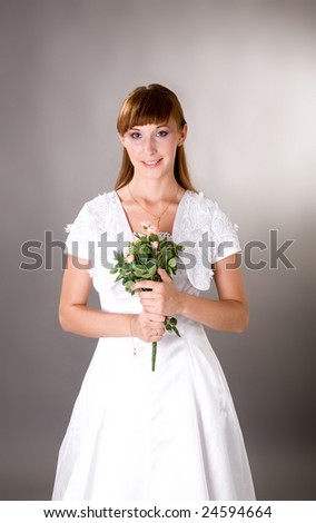 Young bride holding flowers and smiling innocent