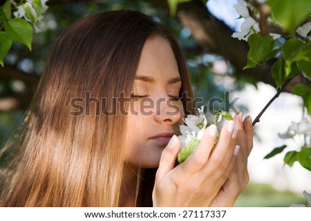 beauty girl smelling apple flower in the park