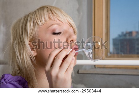 young beauty girl make soap bubble in the room