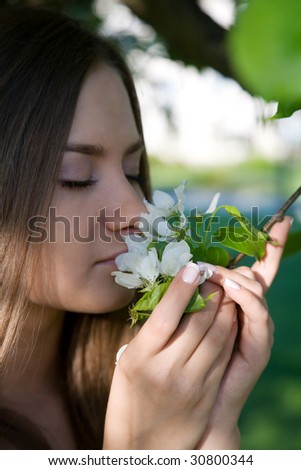 beauty girl smelling apple flower in the park