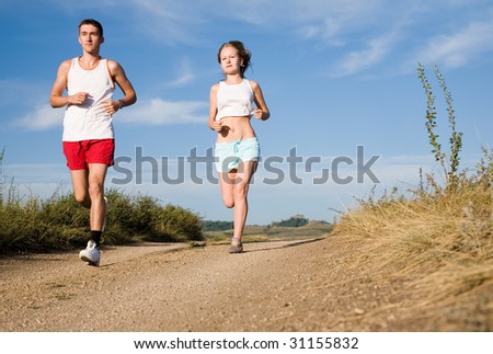 young beauty couple running on the summer road