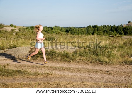 young beauty girl running on the summer road