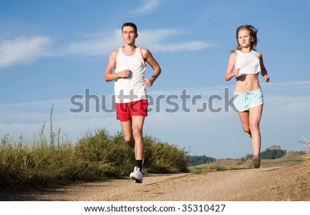 young beauty couple running on the summer road