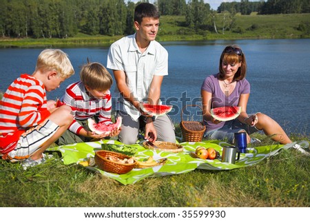 family resting on the lake