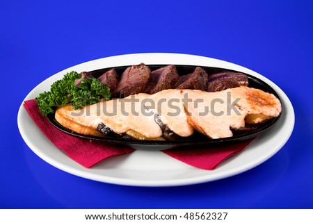 fried meat with potato on blue background