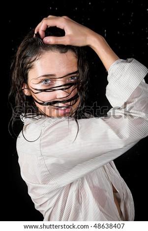 Young girl posing in rain isolated on black background