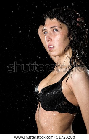 Young girl in underwear in rain isolated on black background