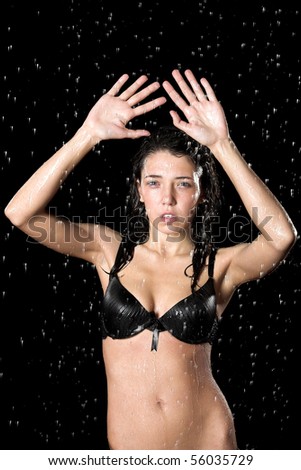 Wet girl posing in rain isolated on black background