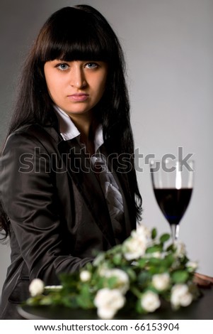 woman sitting at the table with flowers and wine