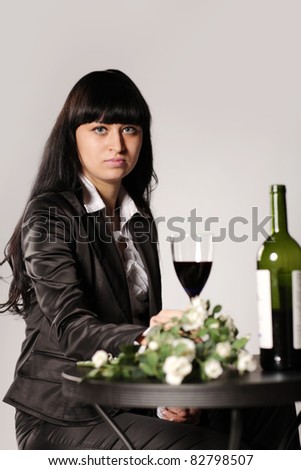 woman sitting at the table with flowers and wine