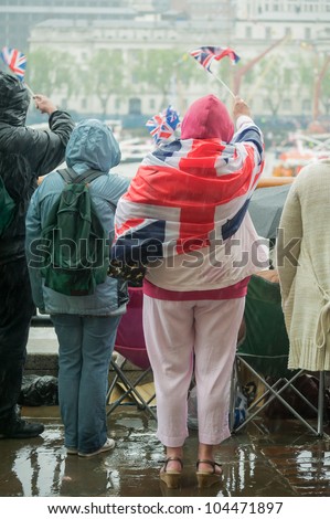 british people in heavy rain celebrating a parade