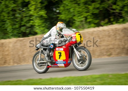 GOODWOOD, UK - JULY 1: British TV presenter and TT racer Steve Parrish riding the famous Barry Sheene Suzuki moto GP bike on the hill course at Goodwood, UK on July 1, 2012