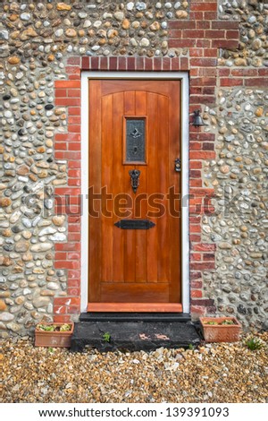 simple wooden front door set in a cobblestone building