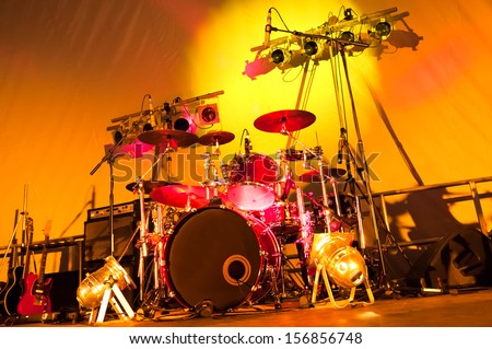 angled view of a rock band stage setup with drums, guitars and spotlights