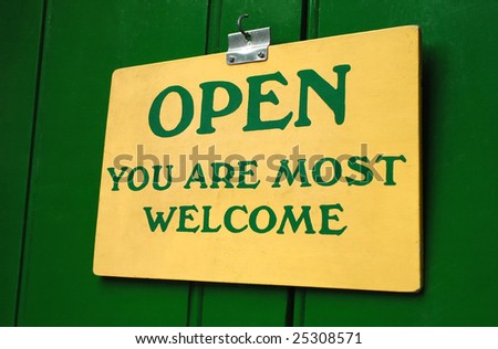 polite old welcome sign hanging in a doorway