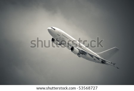 black and white of a passenger aircraft banking through heavy cloud