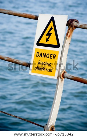 electric shock danger sign on fencing over water