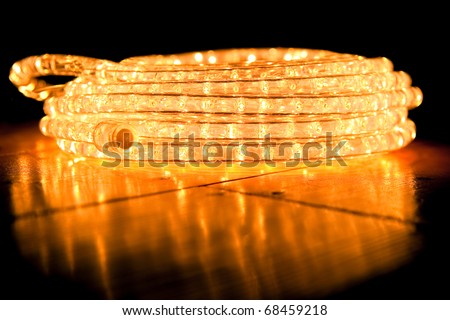 festive abstract of coiled rope lighting on a reflective hardwood floor