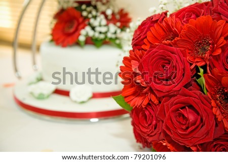 stock photo red wedding flowers with wedding cake in the background