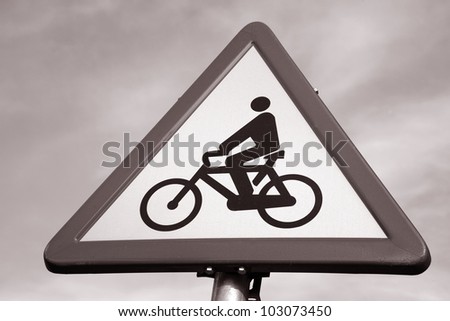 Red and White Bicycle Sign against Blue Sky Background in Black and White Sepia Tone