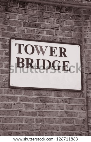 Tower Bridge Sign in London, England, UK on Brick Wall in Black and White Sepia Tone