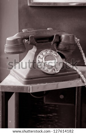 Old Red Telephone in Phone Booth in Black and White Sepia Tone