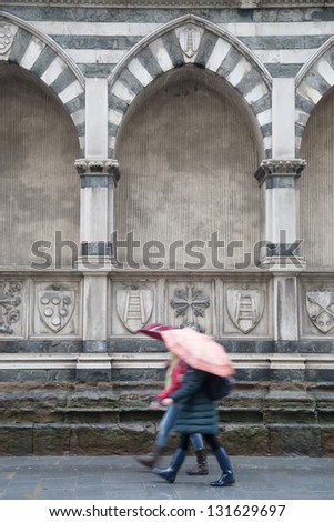 Exterior Facade of Santa Maria Novella Church; Florence; Italy with Two Women Walking with Umbrellas
