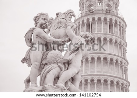 Fountain with Angels - Fontana dei Putti 18th Century and Leaning Tower of Pisa in Piazza dei Miracoli Square, Pisa, Italy in Black and White Sepia Tone