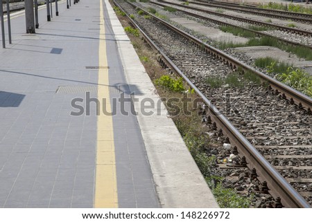 Railroad Tracks and Platform with Yellow Safety Line