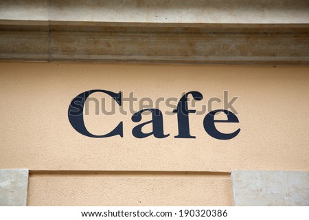 Cafe Sign on Yellow Stone Wall