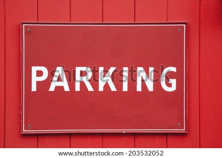 Red and White Parking Sign on Garage Door