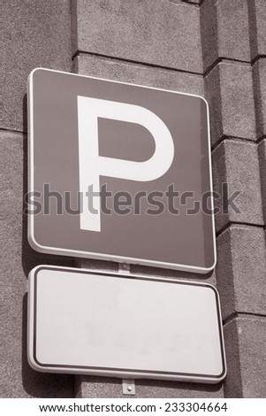 Parking Sign against Stone Wall in Black and White Sepia Tone
