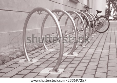 Bike locked up against metal pole in urban setting in Black and White Sepia Tone
