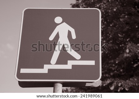 Pedestrian Sign of Man Walking Down Steps in Black and White Sepia Tone