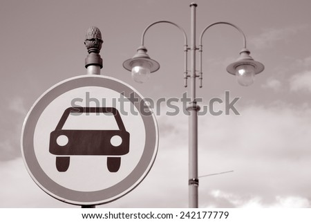 Car Sign and Lamppost against Sky Background in Black and White Sepia Tone