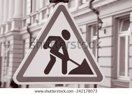 Men at Work Traffic Sign in Urban Setting in Black and White Sepia Tone
