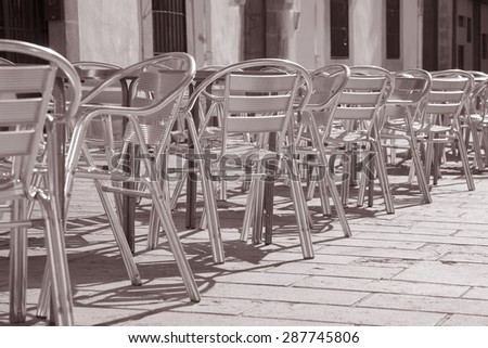 Cafe Tables and Chairs in Outdoor Setting in Black and White Sepia Tone