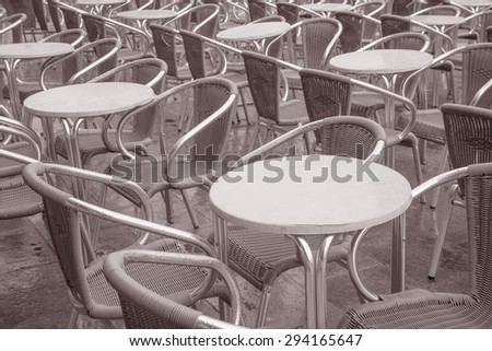 Cafe Tables and Chairs with Waiter in St Marks Square, Venice, Italy in Black and White Sepia Tone