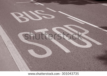 Bus Stop Sign Painted on Road in Black and White Sepia Tone
