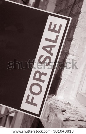 For Sale Sign outside Real Estate Property in Black and White Sepia Tone