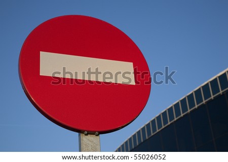 Red no entry sign with modern office detail in the background