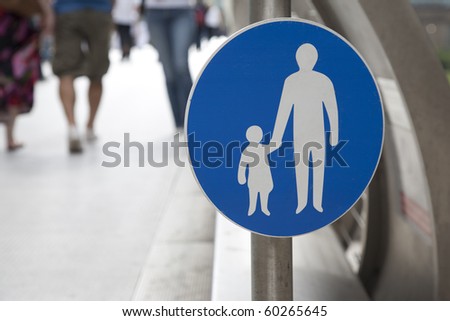 Pedestrian sign with people walking in the background