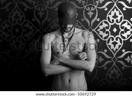 stock photo : Half naked male model with cap and tattoos