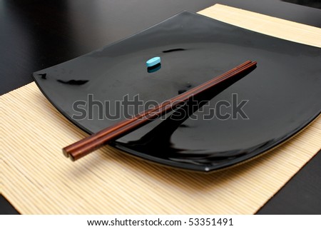 Blue pill on a black plate (focus on pill)