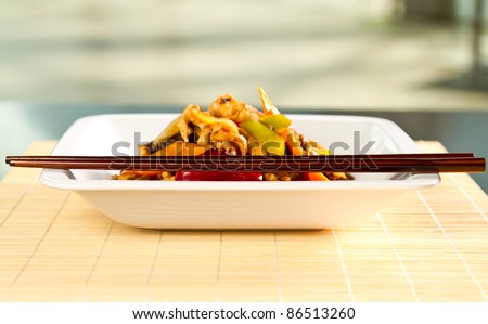 Chinese specialty blured with chopsticks in focus